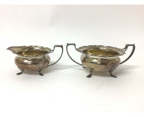 Ellington silver milk jug and sugar basin, of squat form, with scalloped rims and hoof feet, the basin measuring 19.5cm wideT
