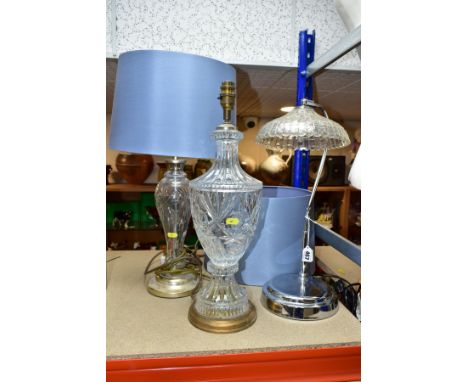 THREE ELECTRIC LAMPS, comprising a cut glass urn shaped table lamp with blue shade, height approximately 49cm excluding shade