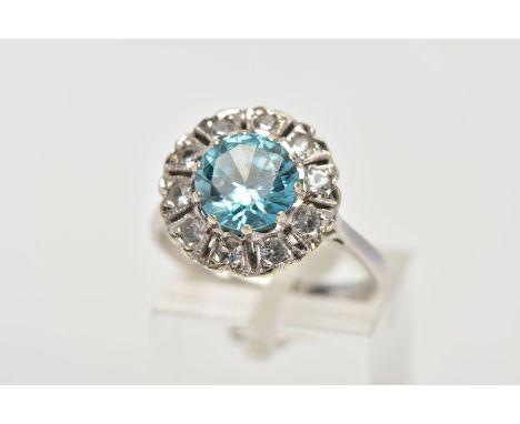 A WHITE METAL GEM SET CLUSTER RING, of a flower shape, centring on a circular cut blue zircon within a surround of circular c
