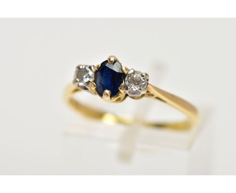 AN 18CT GOLD SAPPHIRE AND DIAMOND THREE STONE RING, centring on a claw set, oval cut blue sapphire, flanked with a round bril