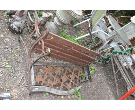 A DISTRESSED CAST IRON  GARDEN BENCH with pierced metal back panel and wooden slatted seat 122cm wide