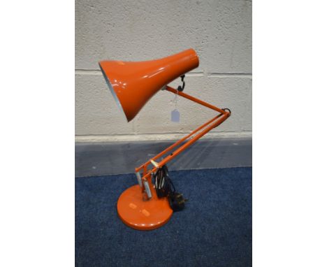 AN ORANGE ANGLE POISE DESK LAMP