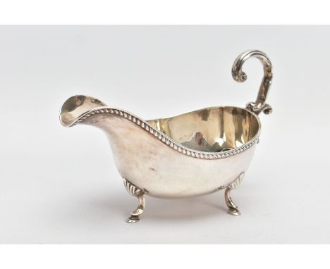 AN EARLY 20TH CENTURY SILVER GRAVY BOAT, with gadrooned top edge, scrolling handle and three feet, silver hallmark for Birmin