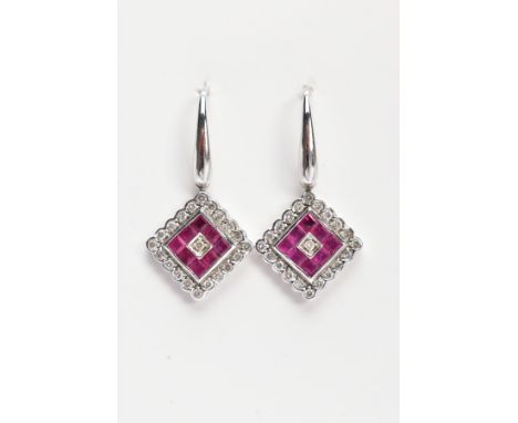 A PAIR OF WHITE METAL, DIAMOND AND RUBY DROP EARRINGS, each drop of a diamond shape, set with square cut rubies and round bri