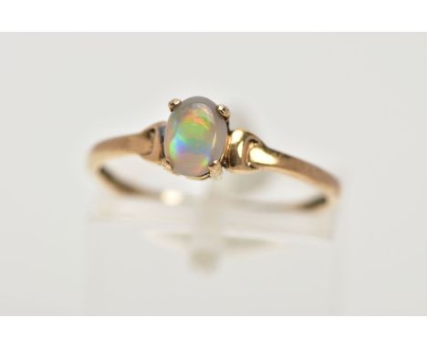 A YELLOW METAL OPAL RING, designed with a claw set, oval opal cabochon, plain polished band stamped '9ct', ring size N, appro