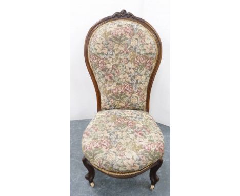 Victorian walnut lady's spoon-back chair, upholstered in floral stuff-over fabric, on ceramic castors, 100cm high.