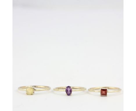 Three silver stacking rings set with opal, amethyst and garnet, (S).