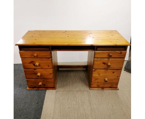A solid pine kneehole desk with graduated drawers and pull out platforms together with a single drawer pine console table, de