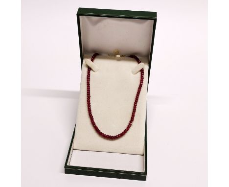A single strand necklace of polished ruby beads on a 9ct gold clasp.