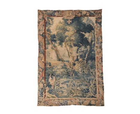 A FLEMISH ARMORIAL SURMOUNTED VERDURE TAPESTRY PANEL LATE 17TH CENTURY Landscape view with river to the foreground- the whole