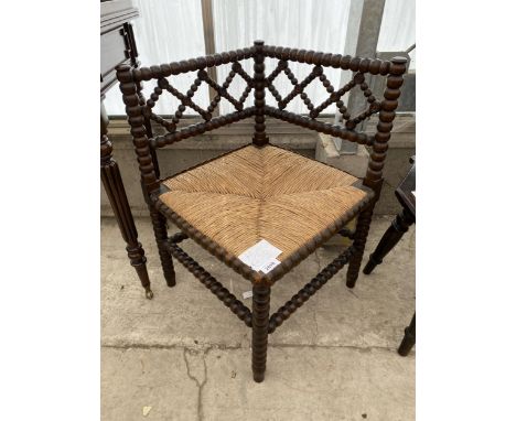 A 19TH CENTURY STYLE CORNER CHAIR WITH RUSH SEAT AND PROFUSE BOBBIN TURNINGS 