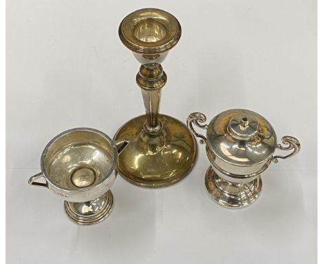 A GROUP OF THREE HALLMARKED SILVER ITEMS COMPRISING A WEIGHTED CANDLESTICK, LIGHTER AND TWIN HANDLED MINIATURE TROPHY CUP, CA