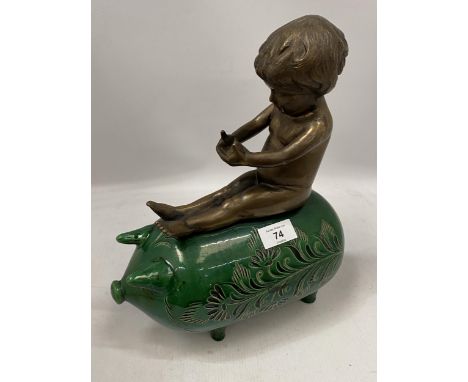 A GREEN VICTORIAN CERAMIC PIG WITH BRONZE MODEL OF A BOY SEATED, HEIGHT 34CM 