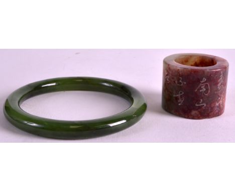 AN EARLY 20TH CENTURY CHINESE SPINACH JADE BANGLE together with an archers ring. (2)