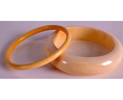 AN EARLY 20TH CENTURY CARVED IVORY BANGLE together with another. 3ins diameter. 