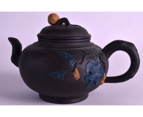 A CHINESE YIXING POTTERY TEAPOT AND COVER 20th century, decorated with foliage. 6.75ins wide. 