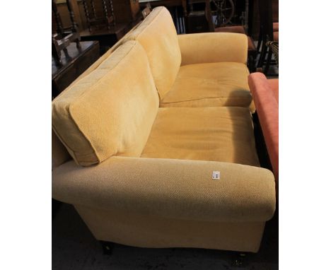 Modern upholstered sofa with scroll arms on brass cups and casters.