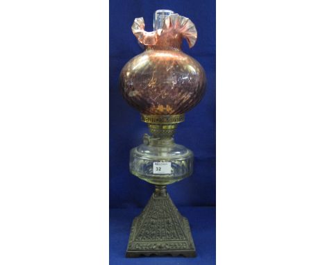 Early 20th Century brass double burner oil lamp with glass reservoir on cast metal conical base, coloured glass shade and cle