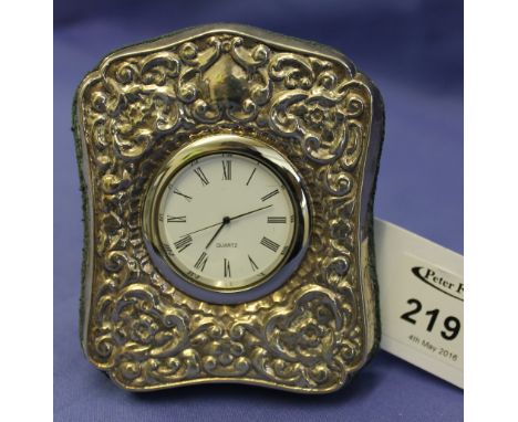 Silver repousse scroll decorated clock frame with inset quartz clock.