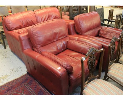 Modern red leather three piece suite comprising two seater sofa and pair of matching armchairs. (3)