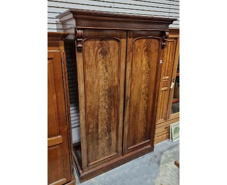 Victorian flame mahogany wardrobe and linenpress with scroll bracket supports above moulded cornice, with arched recessed pan