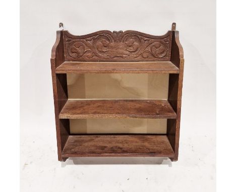 Carved oak hanging bookshelf having three tiers with scrolling carved foliate motifs to the side and back panel, 75cm high x 