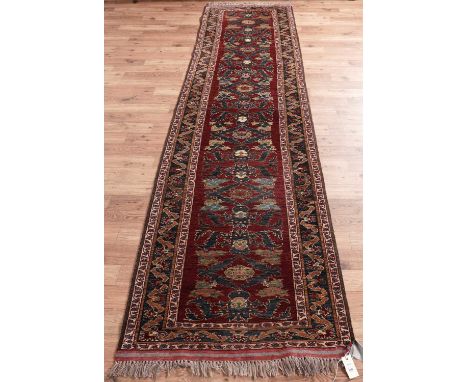 A modern Turkish runner, with floral turkish decoration to claret field, 330 x 83cms.