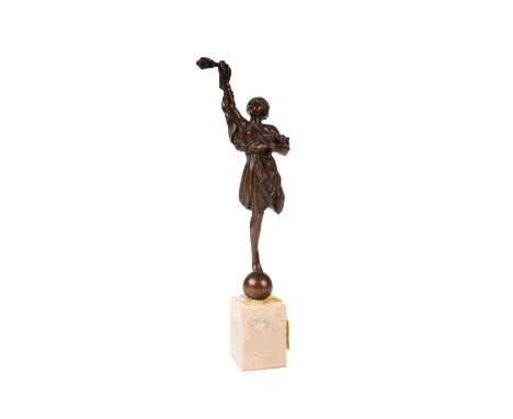 An early 20th Century bronze figure, modelled as a dancer balancing atop a ball, with one arm outstretched holding a torch, r