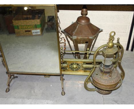 A small brass fire surround, 83cm wide, a suspended brass oil lamp, a brass-framed mirrored fire screen and other items. 