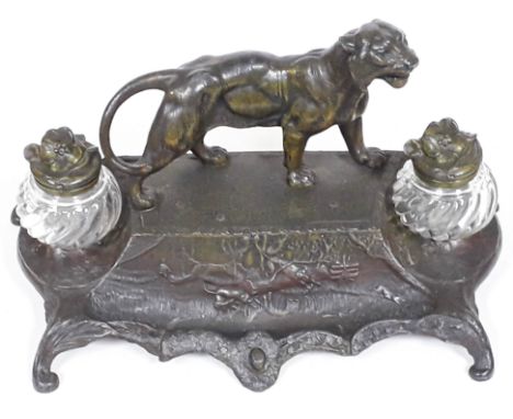 A cold painted spelter standish circa 1900 with mounted tiger and base embossed with hunting scene and having scroll feet, tw
