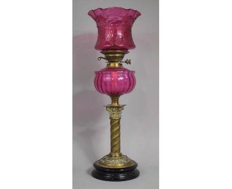 A Victorian Brass Oil Lamp, The Support in The Form of Wrythen Corinthian Column, Cranberry Glass Reservoir and Etched Cranbe