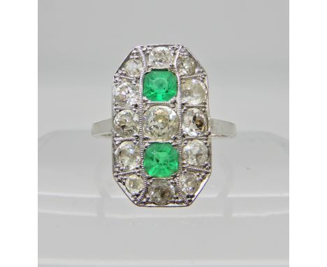 An 18ct white gold diamond and emerald plaque ring, the two step cut emeralds measure 3.8mm x 3.8mm x 2.9mm, surrounded by di