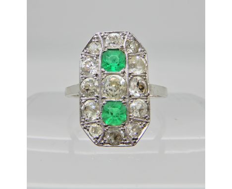 An 18ct white gold diamond and emerald plaque ring, the two step cut emeralds measure 3.8mm x 3.8mm x 2.9mm, surrounded by di