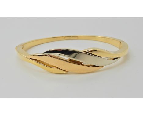 An 18ct gold three colour gold bangle of leaf form, inner dimensions 6.1cm x 5cm, weight 21.1gms