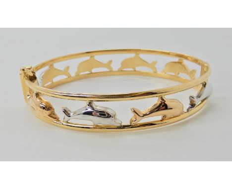 A three colour gold dolphin bangle stamped 750, UAE, inner dimensions 6cm x 5.3cm, weight 15.6gms