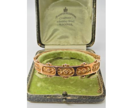 A 9ct gold bangle with a floral theme, hallmarked Birmingham 1884-5, in original box, 1.3cm x 6.7cm, weight 10.8gms