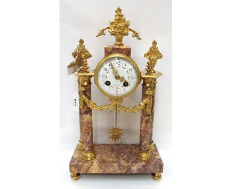 A French pink marble and ormolu mantle clock with enamelled dial