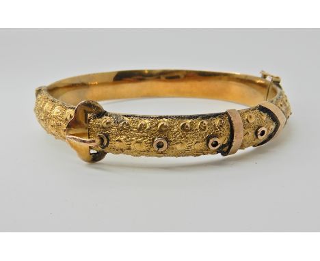 A 9ct gold bangle by Smith &amp; Pepper, dated Birmingham 1918. In the shape of a buckled belt, inner diameter 6cm x 5cm, app
