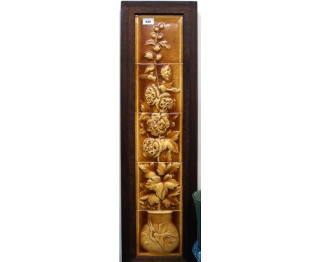 A Burmantofts amber glazed tile panel depicting flowers in a vase, in wooden frame, 85cm long