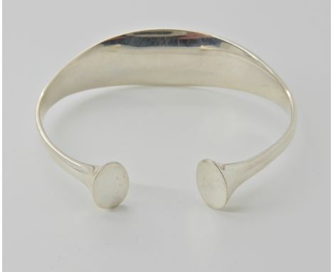 A silver Georg Jensen bangle pattern number 243 designed by Bent Gabrielsen, diameter 7cm x 5.5cm, weight 35.1gms