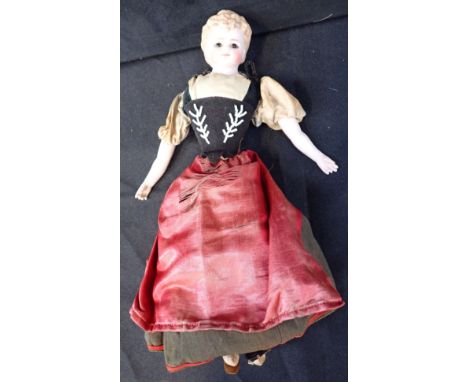 A 19TH CENTURY BISQUE HEAD DOLL with cloth body, the shoulder with suspension chains, 29cm long, with apparently original clo