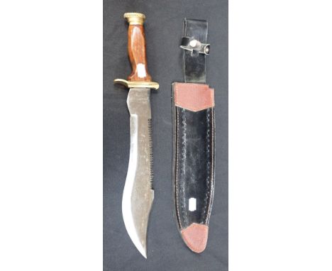 A SAW BACK KNIFE with steel blade and brass mounted wooden hilt, 45cm long, with leather scabbard 