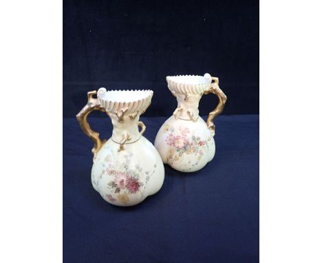 A PAIR OF ROYAL WORCESTER BLUSH IVORY JUGS with gilt twig handles, and painted with flowers 19cm high (worn gilt)