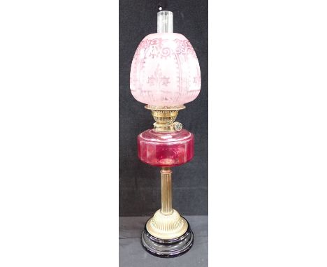 A 19TH CENTURY BRASS TABLE OIL LAMP WITH PNK GLASS RESERVOIR AND SHADE 