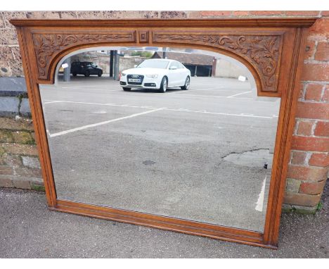 AN EDWARDIAN OAK-FRAMED RECTANGULAR OVERMANTEL MIRROR with carved spandrels 120cm wide