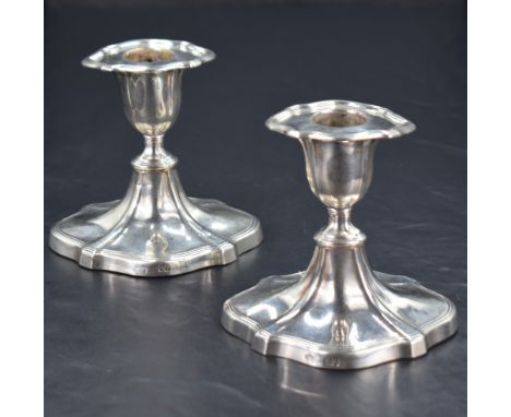 A pair of Edwardian silver candlesticks, of Chippendale influenced design with swept shaped oval foot, marks for London 1901,