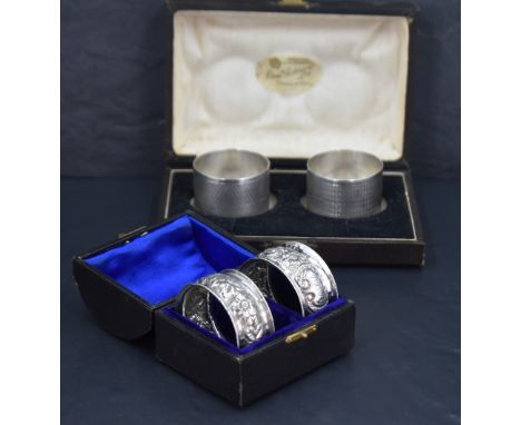 A pair of late Victorian silver napkin rings, of cylindrical form with engine-turned decoration and vacant circular cartouche