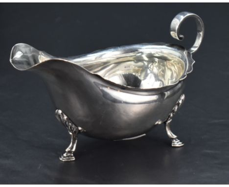 An Edwardian silver gravy boat, of traditional design, having a short flared rim, generous spout and opposing scrolled handle