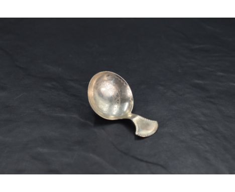 A George III silver caddy spoon, of pleasing proportions and having a circular bow bright-cut with circular motif and wriggle