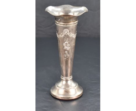 An Edwardian silver trumpet vase, with flared and ruffled rim over the tapering body embossed with foliate swags and pendants